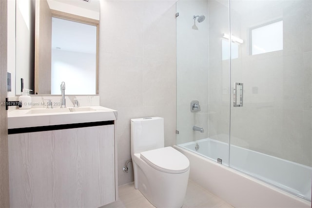 full bathroom featuring shower / bath combination with glass door, tile patterned floors, vanity, and toilet