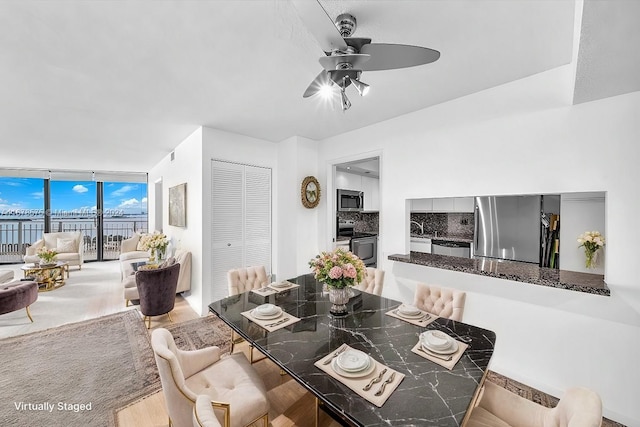 dining room featuring floor to ceiling windows, hardwood / wood-style flooring, and ceiling fan