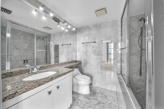 bathroom featuring vanity, tile walls, and toilet