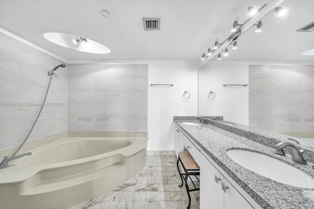 bathroom featuring vanity and tiled shower / bath