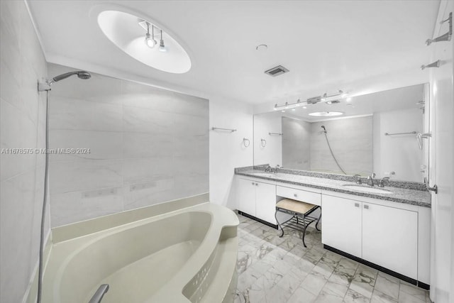 bathroom featuring vanity and tiled shower / bath