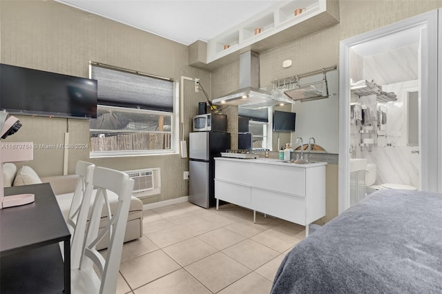 tiled bedroom featuring sink, a wall mounted air conditioner, and stainless steel fridge