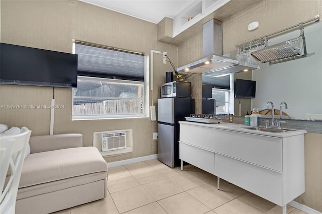 kitchen with a wall mounted air conditioner, light tile patterned flooring, island exhaust hood, and sink