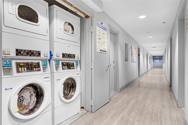 clothes washing area with light hardwood / wood-style floors and stacked washer and clothes dryer