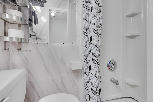 bathroom with tile walls, a shower with shower curtain, and toilet