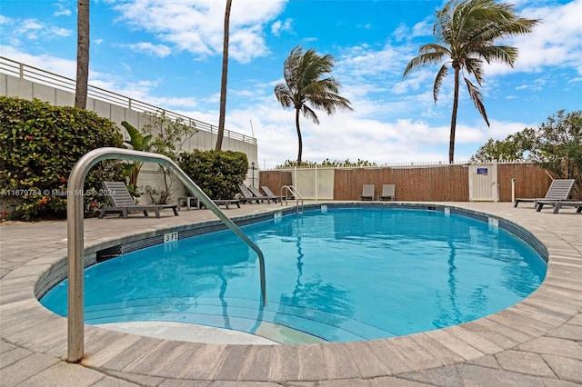 view of pool featuring a patio and a storage unit