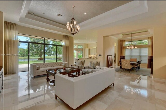 living room with a chandelier and a raised ceiling