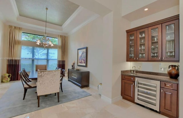 dining room with wet bar, beverage cooler, a raised ceiling, and a notable chandelier