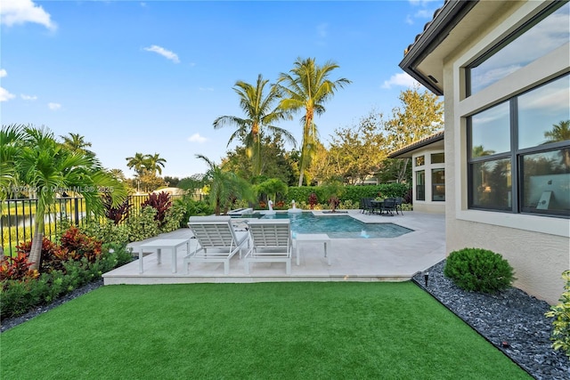 view of swimming pool with a patio area and a yard