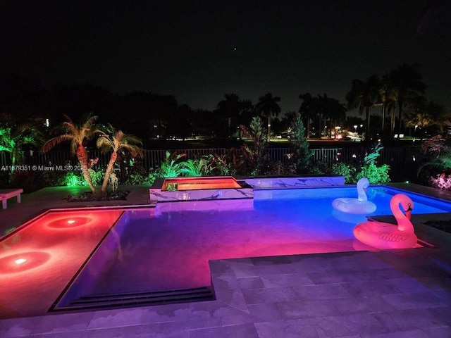 pool at twilight featuring a patio