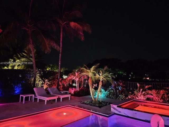 pool at twilight featuring a patio