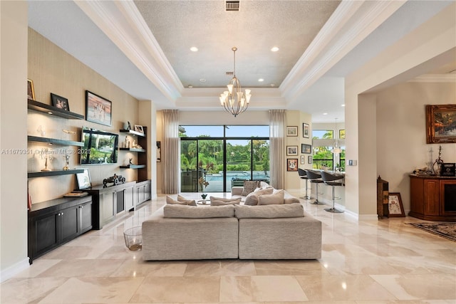 living room with an inviting chandelier, a textured ceiling, a tray ceiling, and ornamental molding