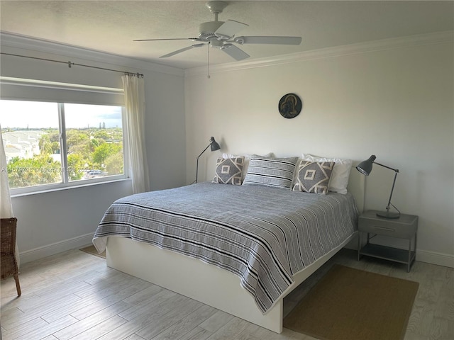 bedroom with light wood-type flooring, ceiling fan, and ornamental molding