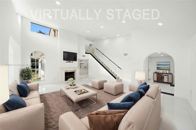 living room featuring a towering ceiling and light tile patterned floors