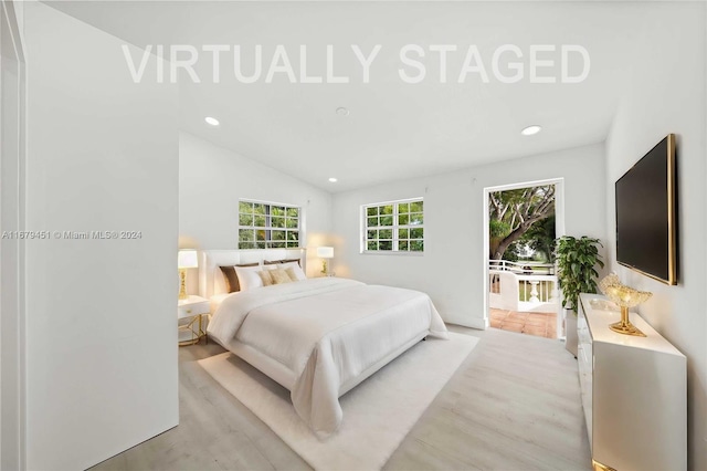 bedroom with vaulted ceiling and light wood-type flooring