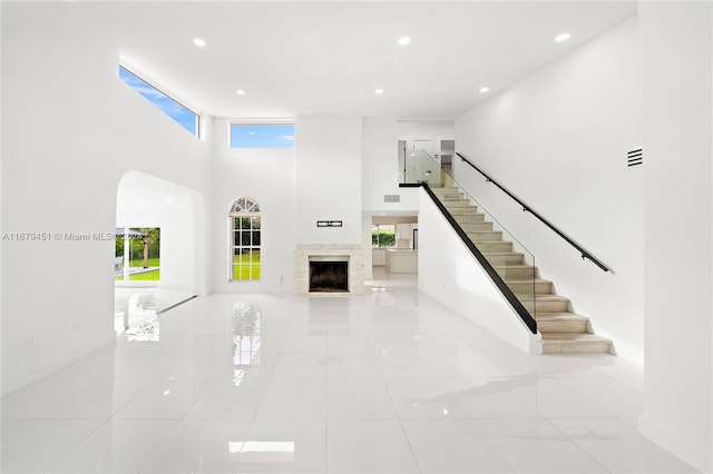 unfurnished living room featuring a high ceiling and light tile patterned flooring