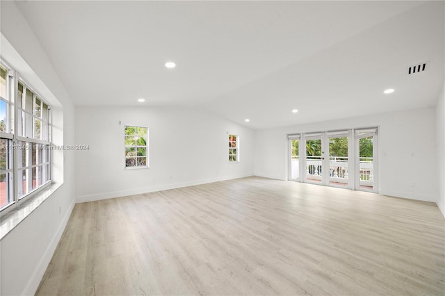 empty room featuring french doors, vaulted ceiling, and light hardwood / wood-style flooring