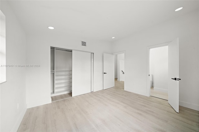 unfurnished bedroom with a closet and light wood-type flooring