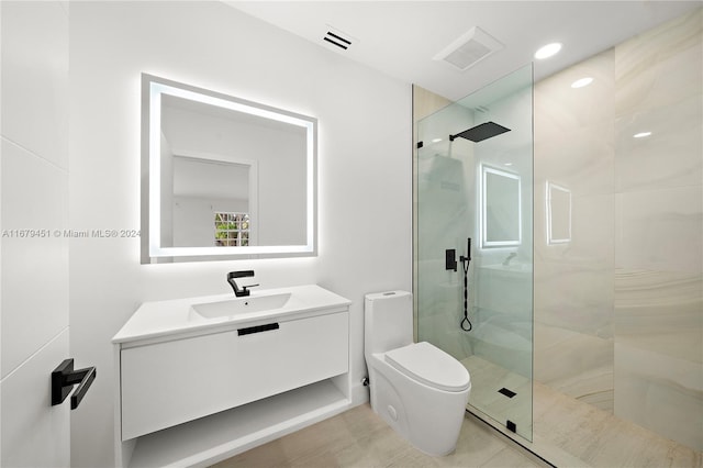 bathroom featuring vanity, tiled shower, and toilet