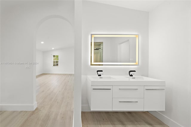 bathroom featuring vanity, wood-type flooring, and lofted ceiling