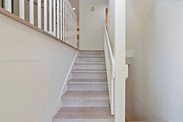 stairway featuring a textured ceiling