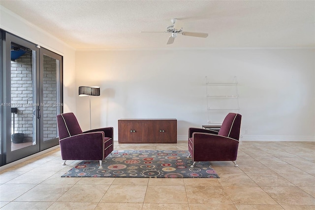 living area featuring ceiling fan, crown molding, a textured ceiling, and light tile patterned floors