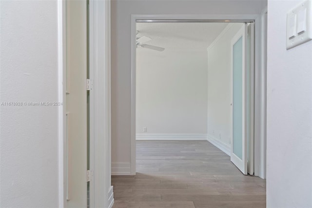 hall with light hardwood / wood-style floors and a textured ceiling