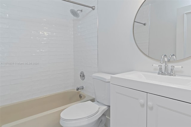 full bathroom featuring tiled shower / bath, vanity, and toilet