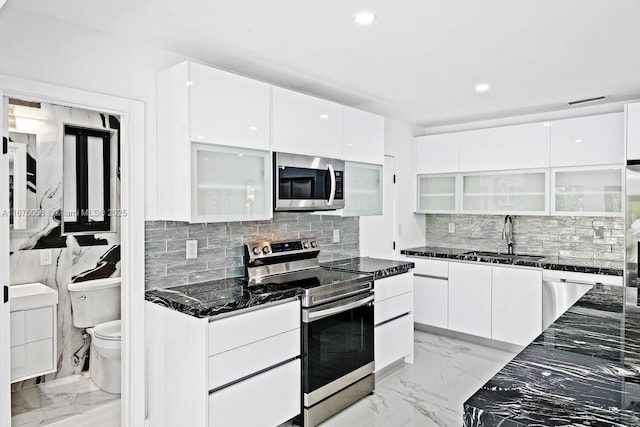 2340 NE 194th St, Miami, FL 33180 - kitchen featuring stainless steel appliances, modern cabinets, a sink, white cabinetry, and recessed lighting