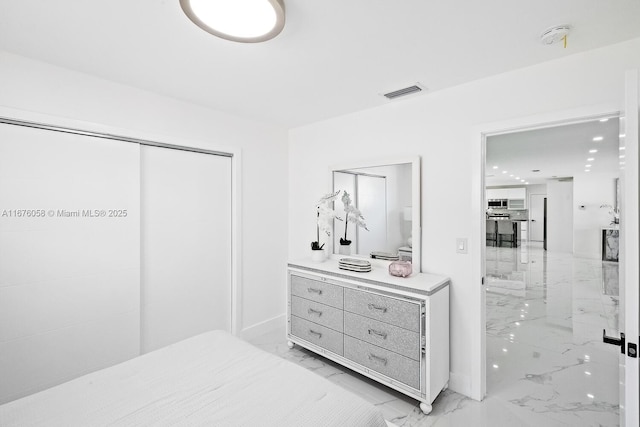 2340 NE 194th St, Miami, FL 33180 - bedroom with light marble finish flooring, ensuite bathroom, a closet, and baseboards