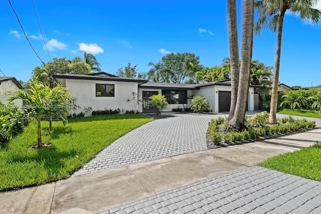 view of front of home featuring a front yard and a garage