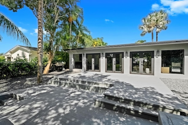 back of house with a wooden deck and french doors