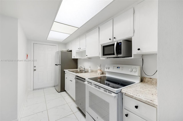 kitchen with stainless steel appliances, white cabinetry, and sink