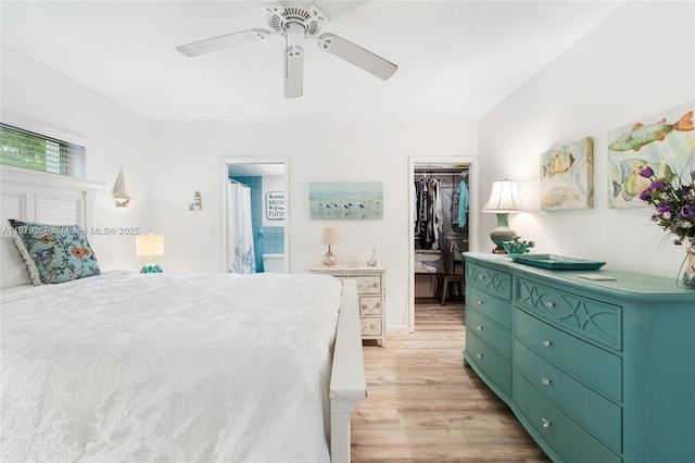 bedroom with ensuite bath, a spacious closet, ceiling fan, a closet, and light wood-type flooring