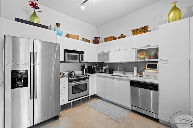 kitchen with appliances with stainless steel finishes, sink, and white cabinets