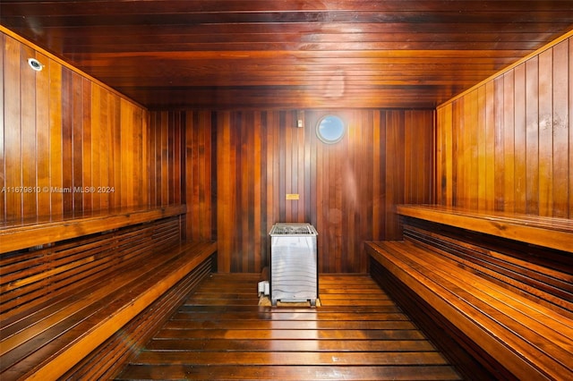 view of sauna / steam room featuring wood walls, wooden ceiling, and hardwood / wood-style floors