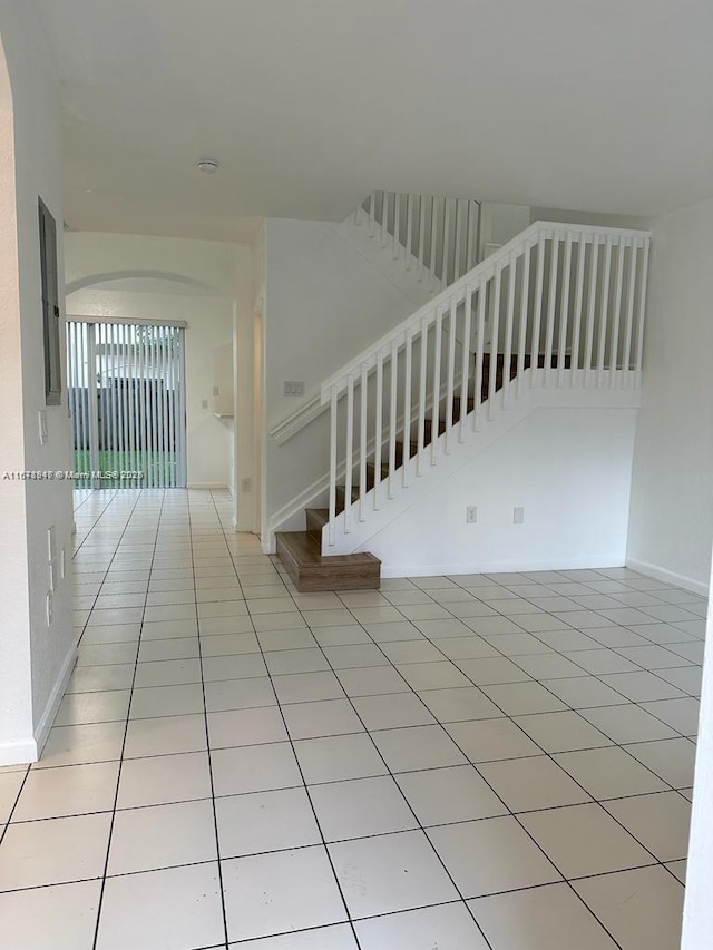 spare room featuring electric panel and light tile patterned flooring