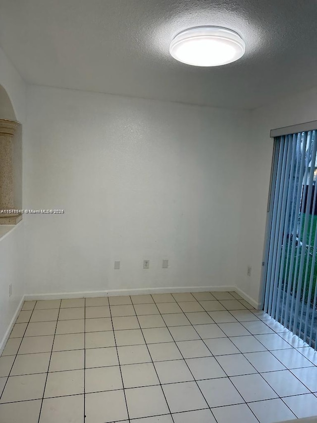 tiled spare room with a textured ceiling