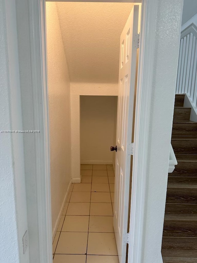 hall with light tile patterned floors