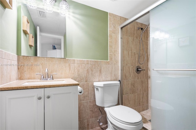 bathroom with decorative backsplash, tile walls, toilet, a shower with shower door, and vanity