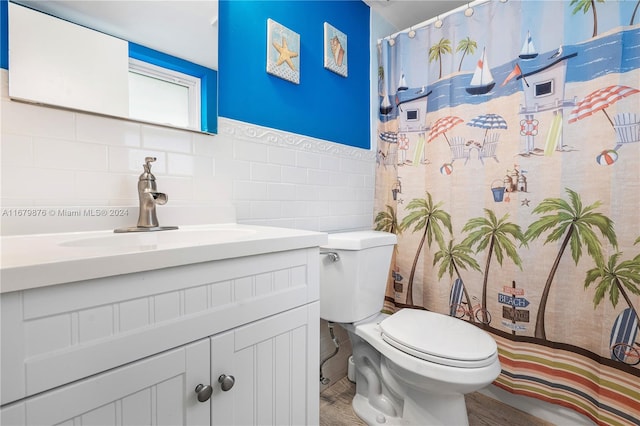 bathroom with hardwood / wood-style flooring, tile walls, toilet, vanity, and curtained shower