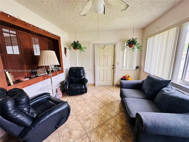 living room with a textured ceiling, tile patterned floors, and ceiling fan