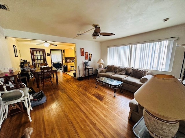 living room with wood-type flooring and ceiling fan