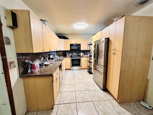 kitchen with appliances with stainless steel finishes, light brown cabinets, tasteful backsplash, and sink