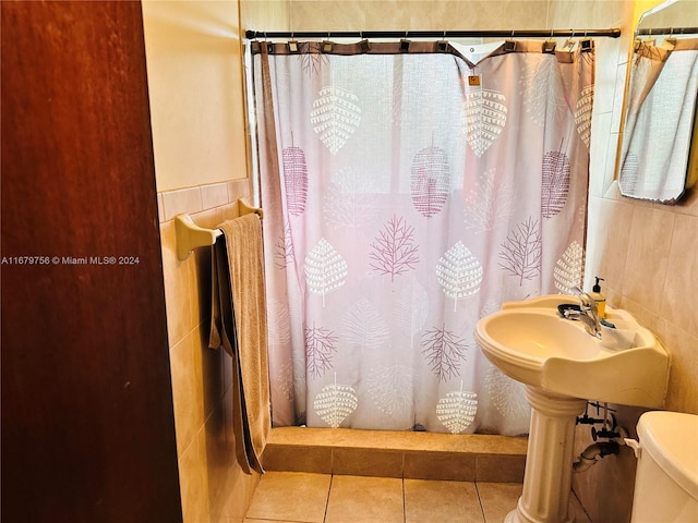 bathroom with a shower with shower curtain, toilet, tile walls, and tile patterned flooring