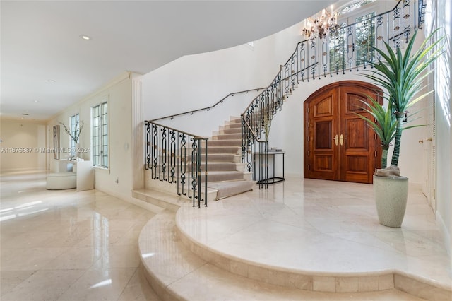 entryway with a chandelier and crown molding