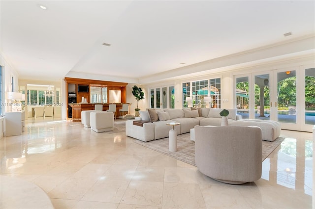 living room with ornamental molding, french doors, and a healthy amount of sunlight