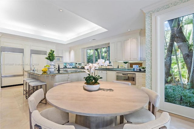 dining space featuring a healthy amount of sunlight and a raised ceiling