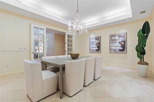 dining area featuring a tray ceiling, a notable chandelier, and ornamental molding