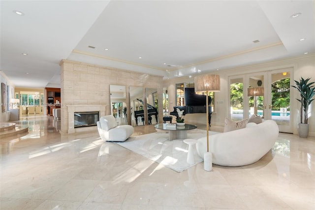 living room with crown molding, french doors, a healthy amount of sunlight, and a fireplace